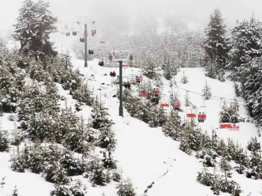 red ski lifts going up a snowy mountain in Bariloche, Argentina