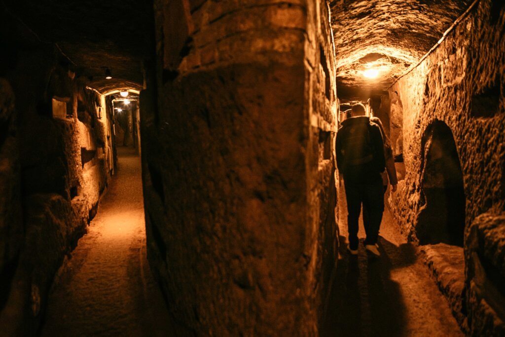 Two passageways in the Rome catacombs during a group tour