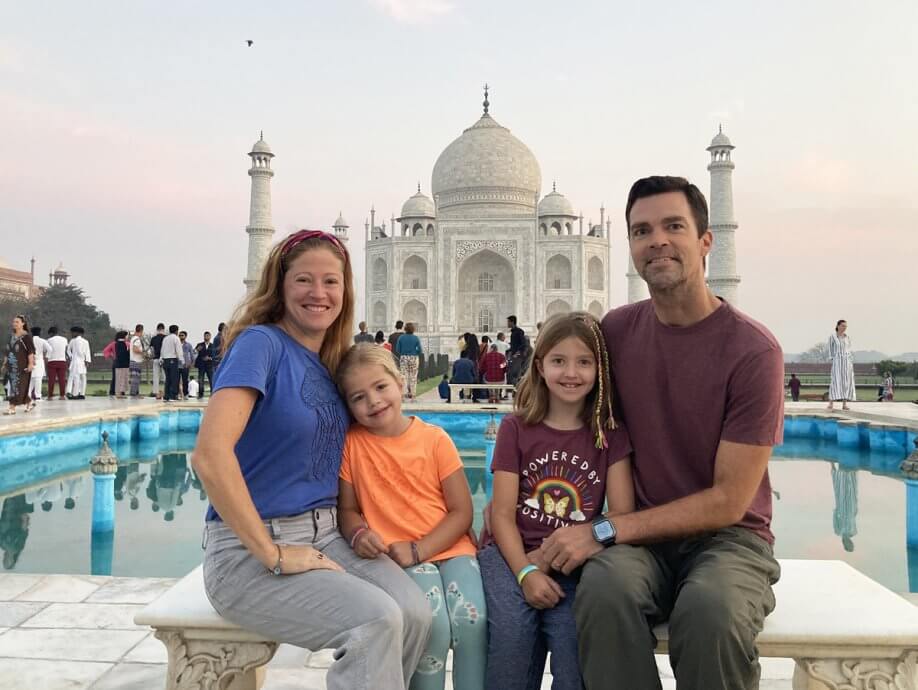 Family sitting on Diana's Bench in front of the Taj Mahal