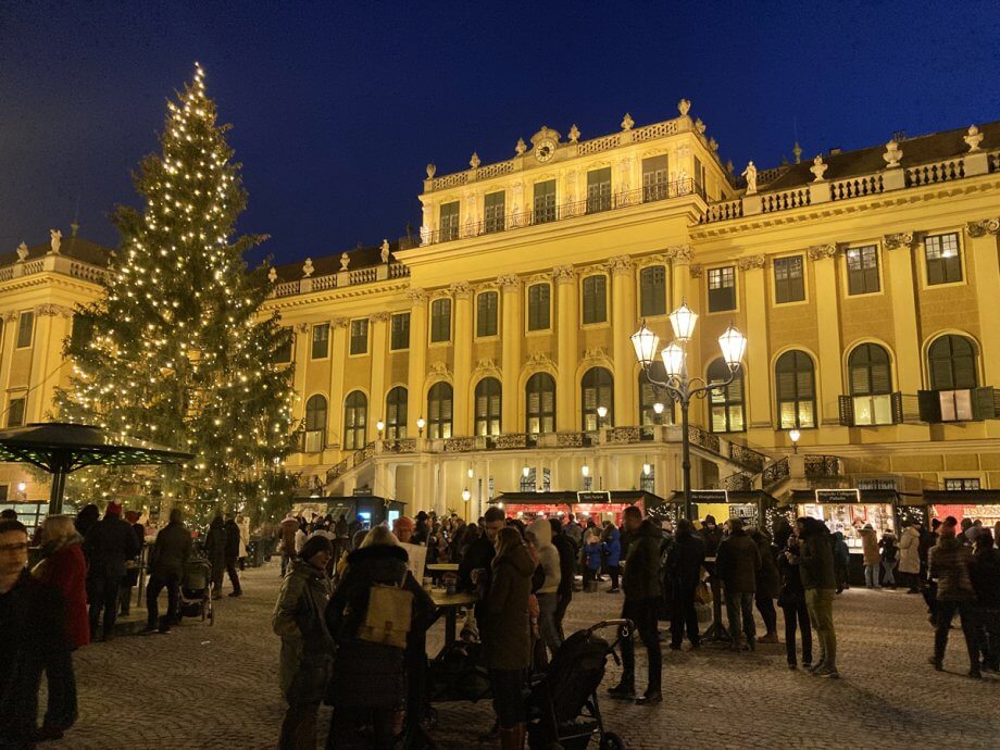 Schonbrunn Palace Christmas Market with crowds and a large Christmas Tree